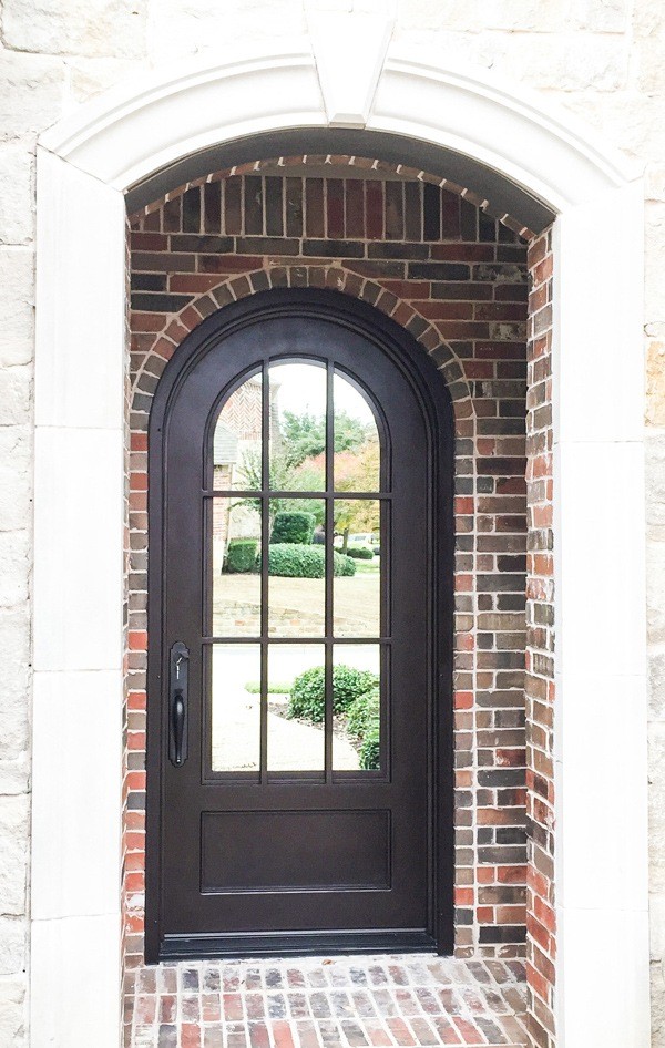 Black iron door on brick home