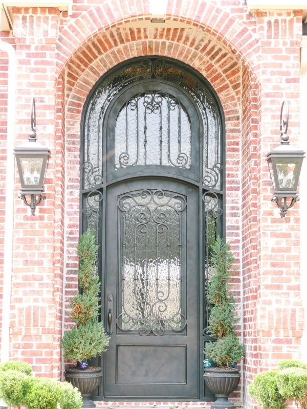 Eyebrow top single door with bronze finish and rounded window above