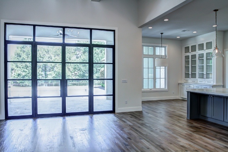 Large open concept kitchen and living with iron work double doors into back yard