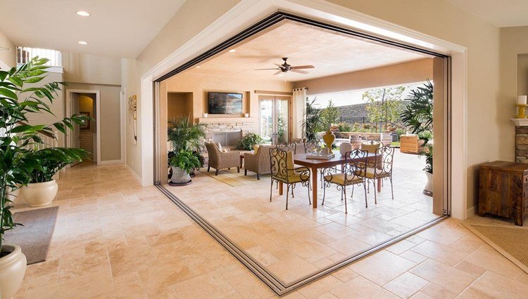 Outdoor dining and living room open to house through sliding glass wall