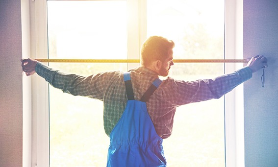 Man measuring the space for windows