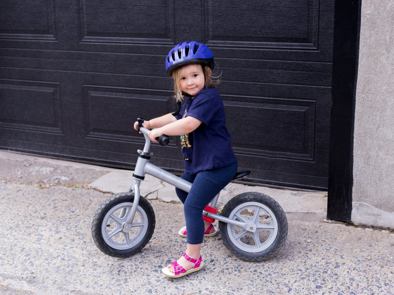 little girl on bike in front of garage door